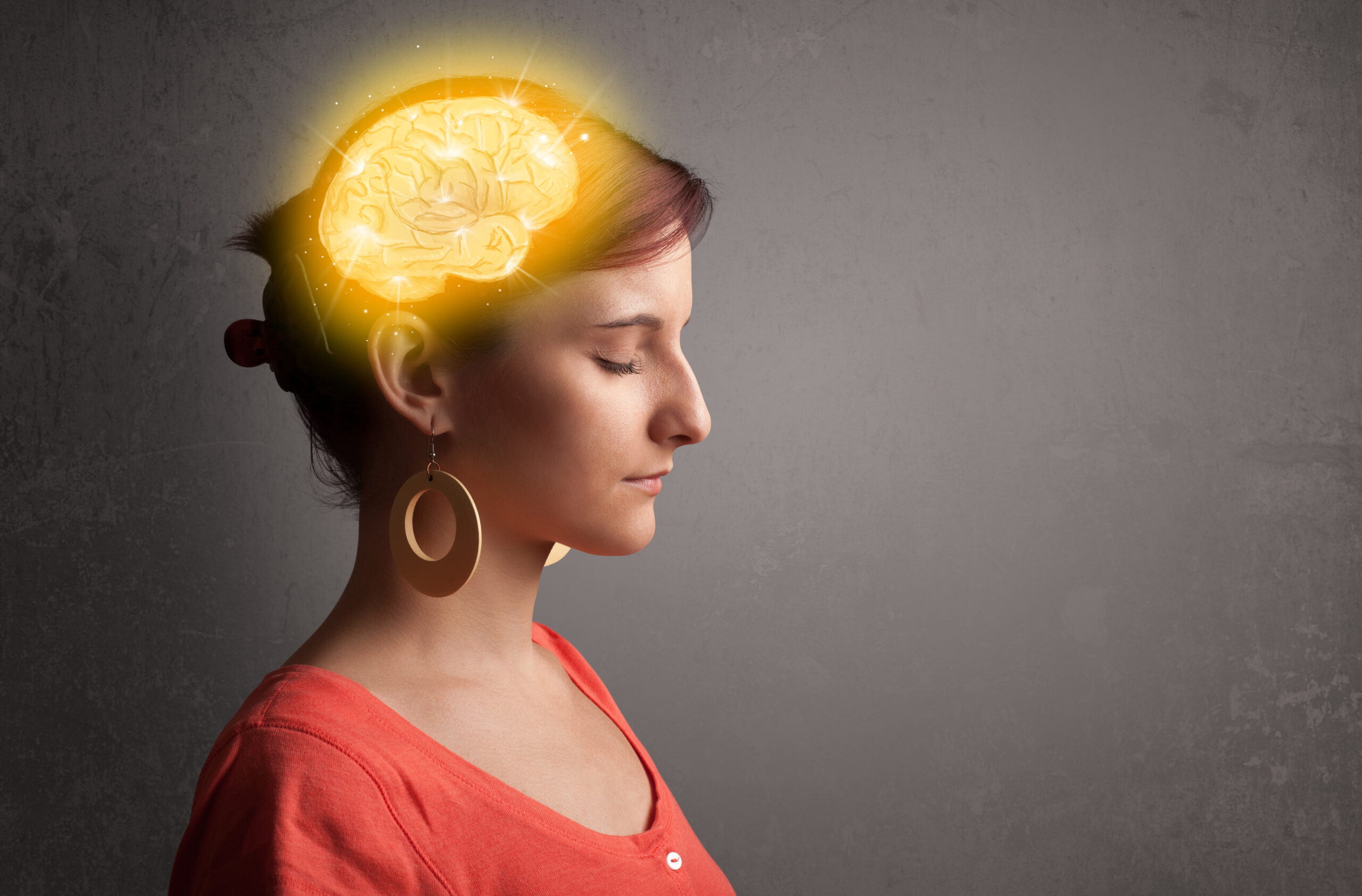 Young girl thinking with glowing brain illustration on grungy background